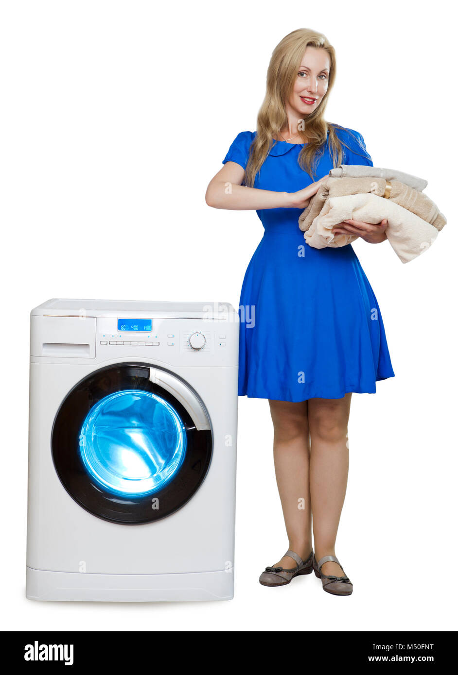 Happy young woman in a blue dress near the new washing machine Stock Photo
