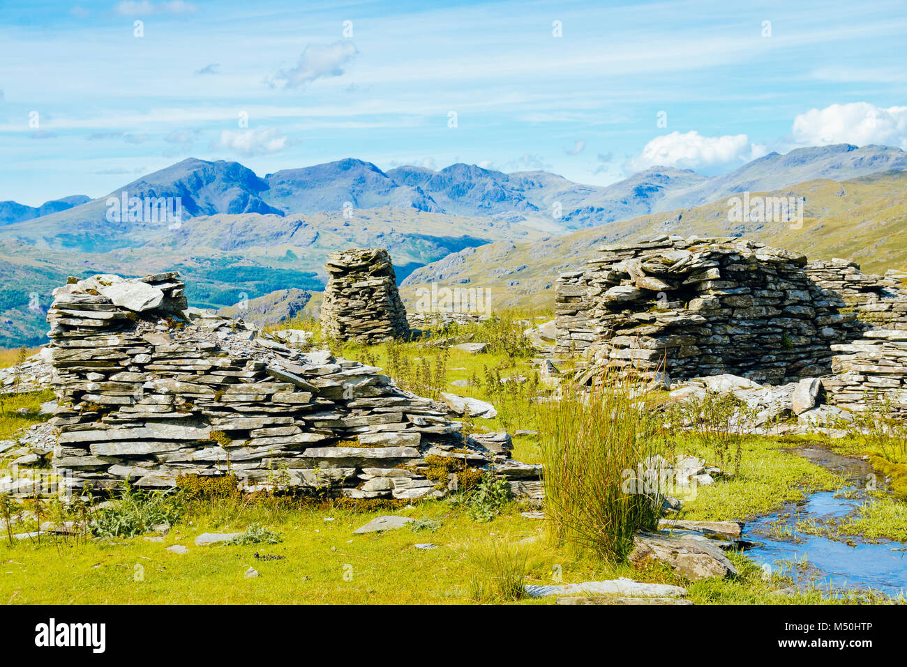 Quarry ruins at Walna Scar Quarries in the English Lake District with Scafell and Scafell Pike in the distance Stock Photo