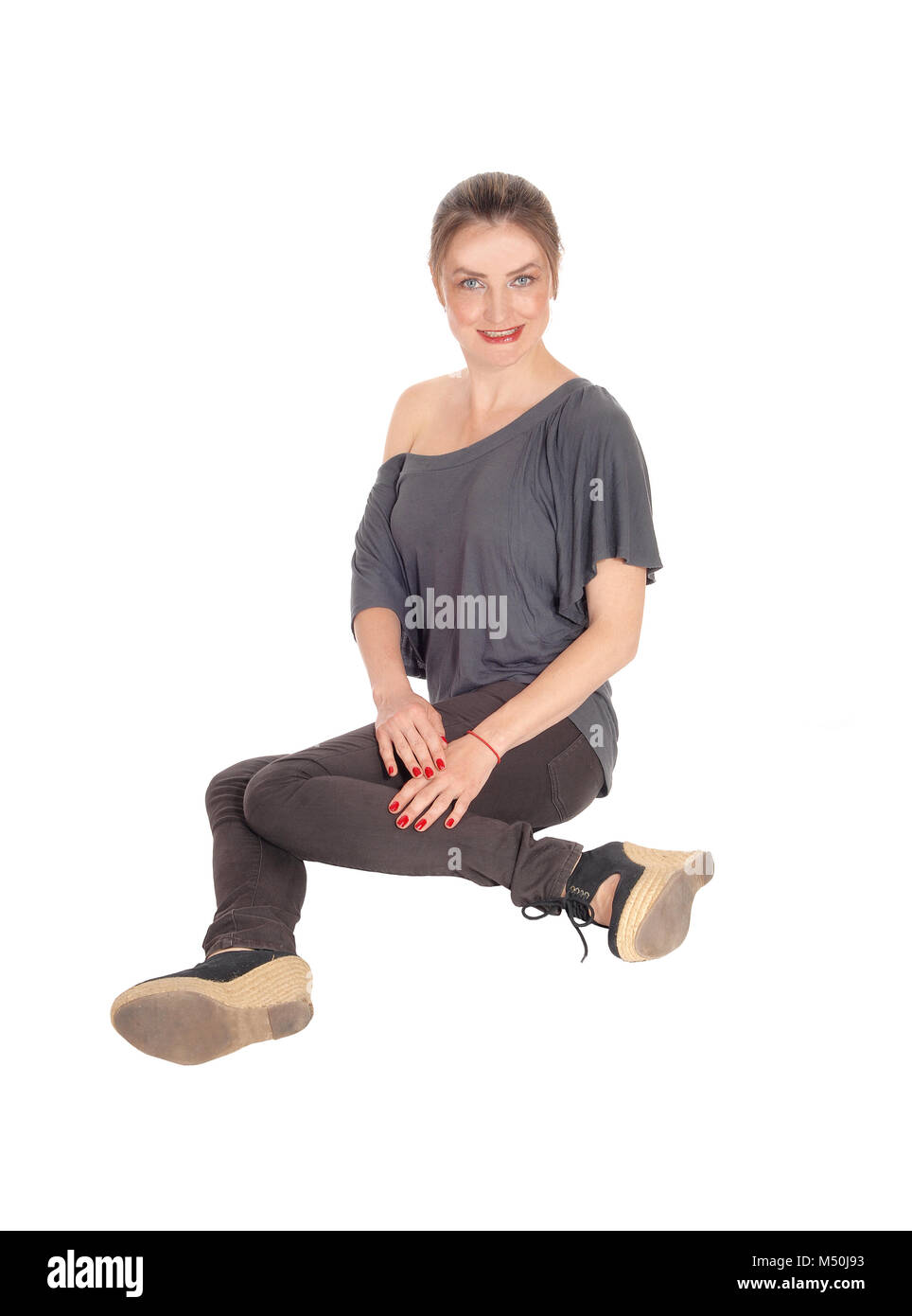 Young woman sitting on floor and smiling Stock Photo - Alamy