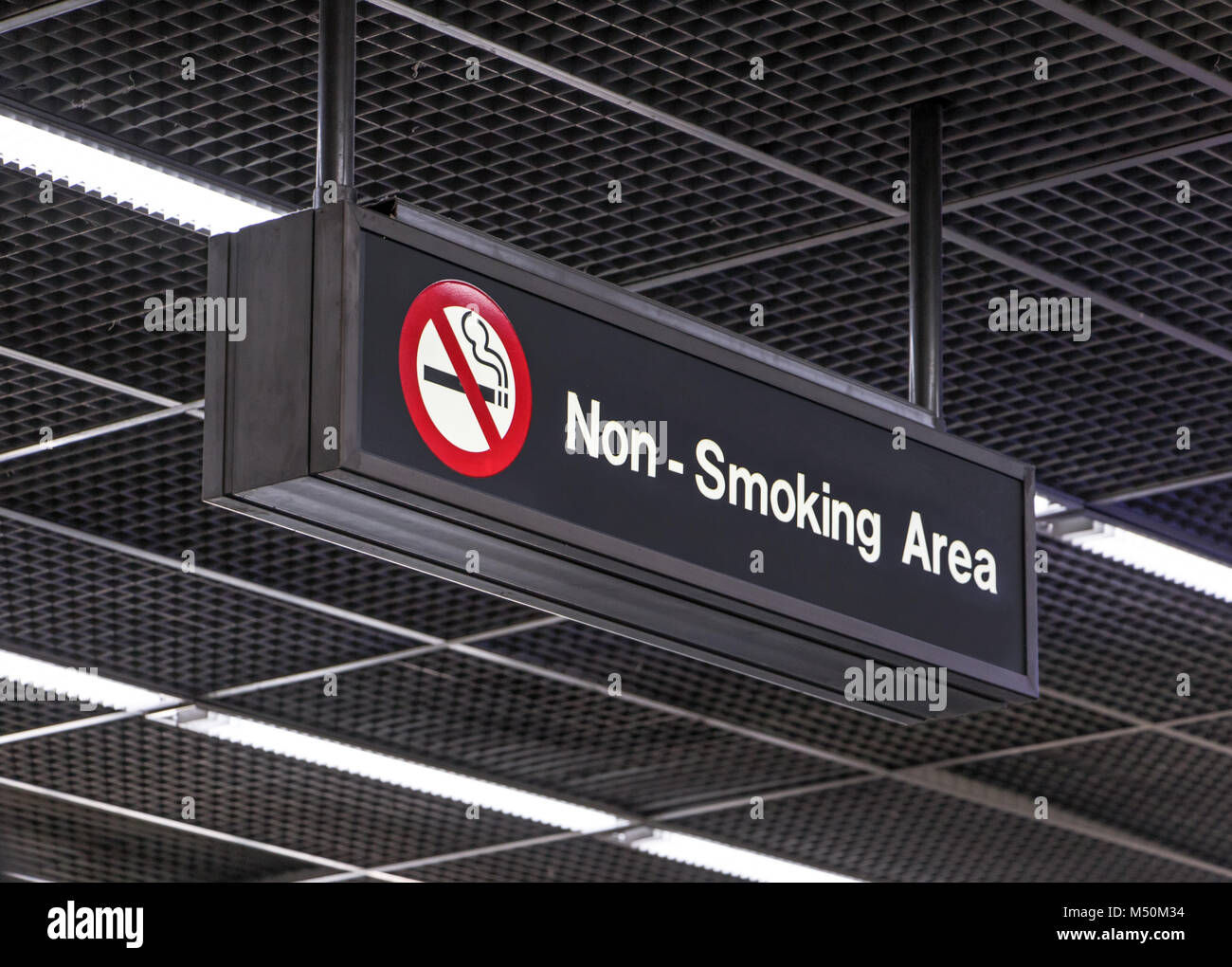 Notification signs for the smoking ban hang from the airport terminal ceiling. Non smoking area. Stock Photo