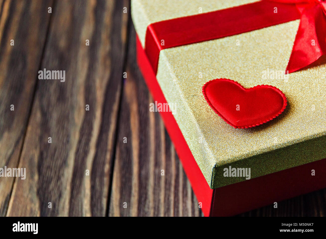 gift box with red bow and heart on wooden background. gift with love ...