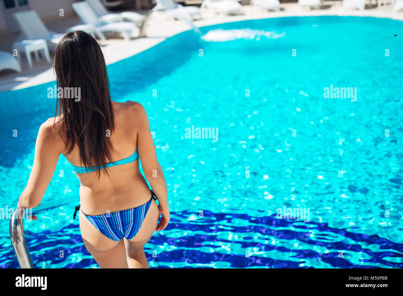 Young Happy Woman In The Black Swimsuit With Shapely Body Near The Swimming  Pool At The Resort With Blurred Background Stock Photo, Picture and Royalty  Free Image. Image 73435109.