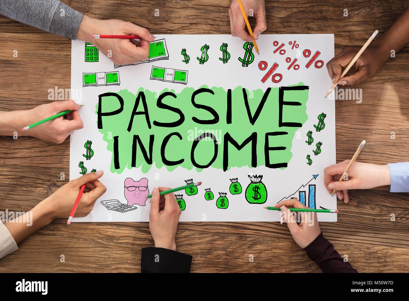 Group Of People Drawing Passive Income Concept In Notepad Stock Photo