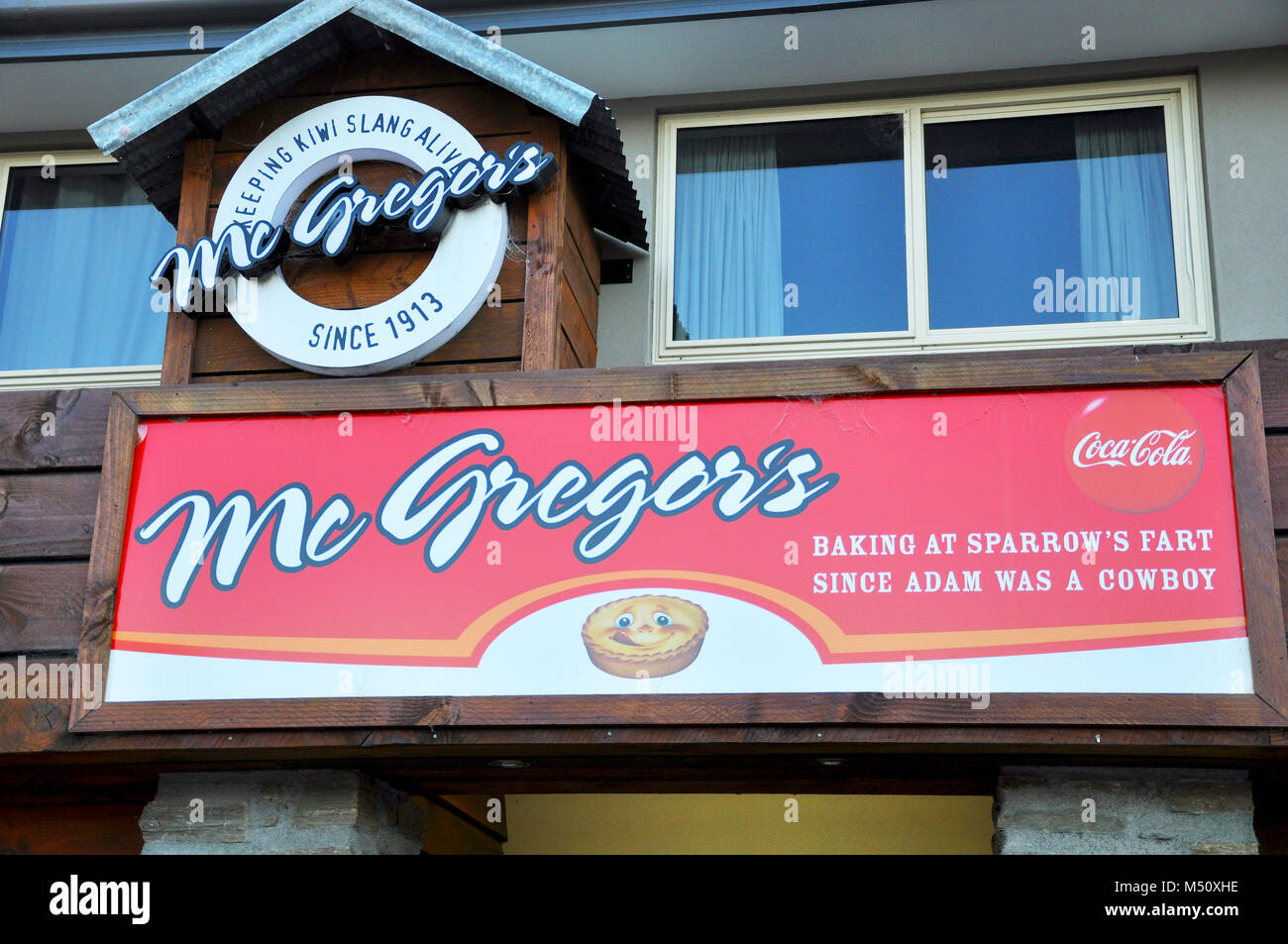 McGregor's bakery, Wanaka New Zealand. Keeping Kiwi slang alive. Baking at sparrow's fart since adam was a cowboy. Shop front sign. Humorous Stock Photo