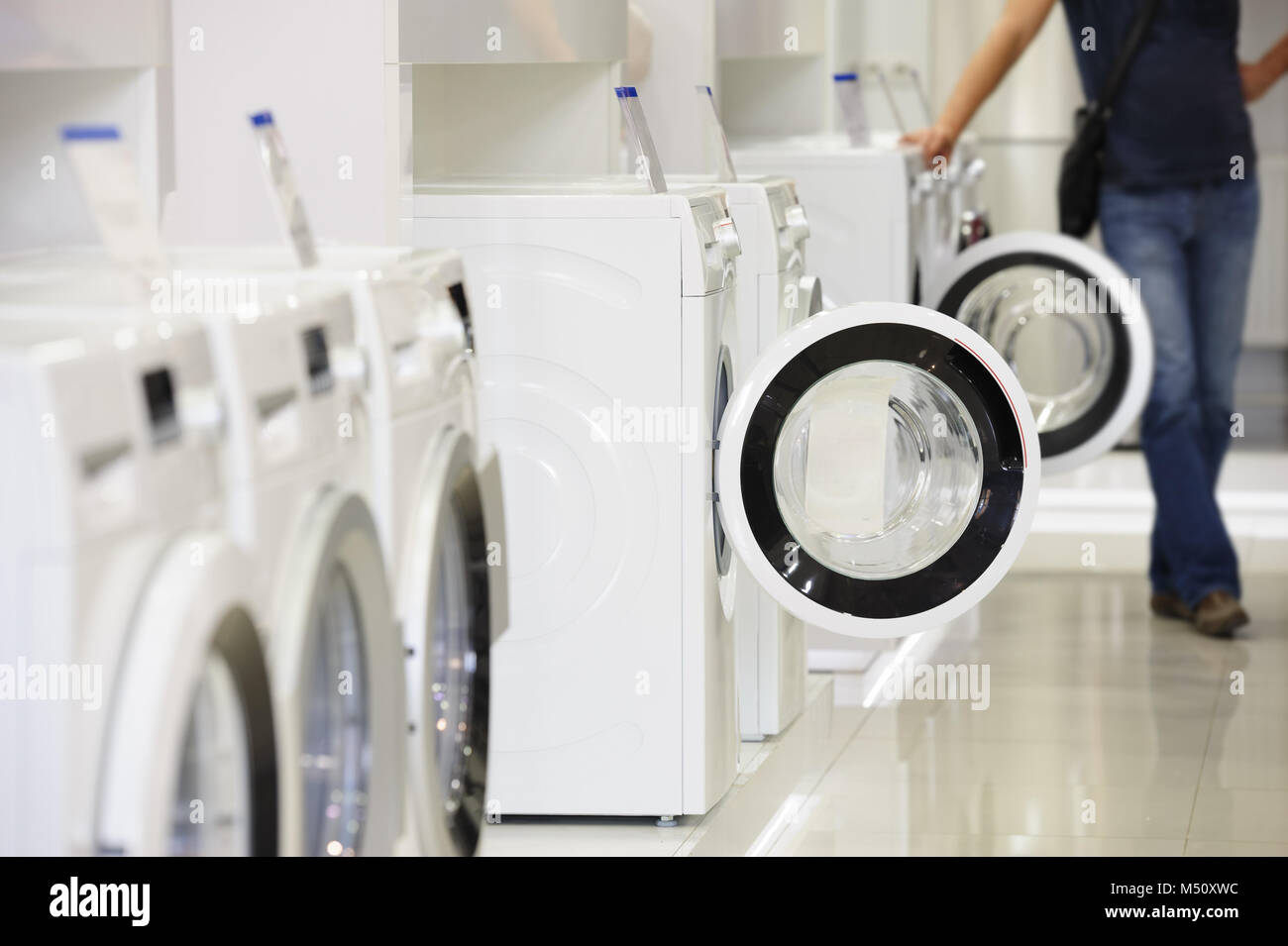 washing machines in appliance store and defocused buyer Stock Photo
