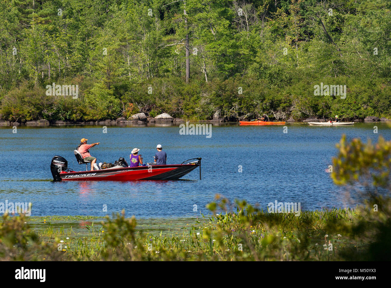 Families engage in recreational boating fishing and kayaking on Squam Lake in Moultonborough, NH, USA. Stock Photo