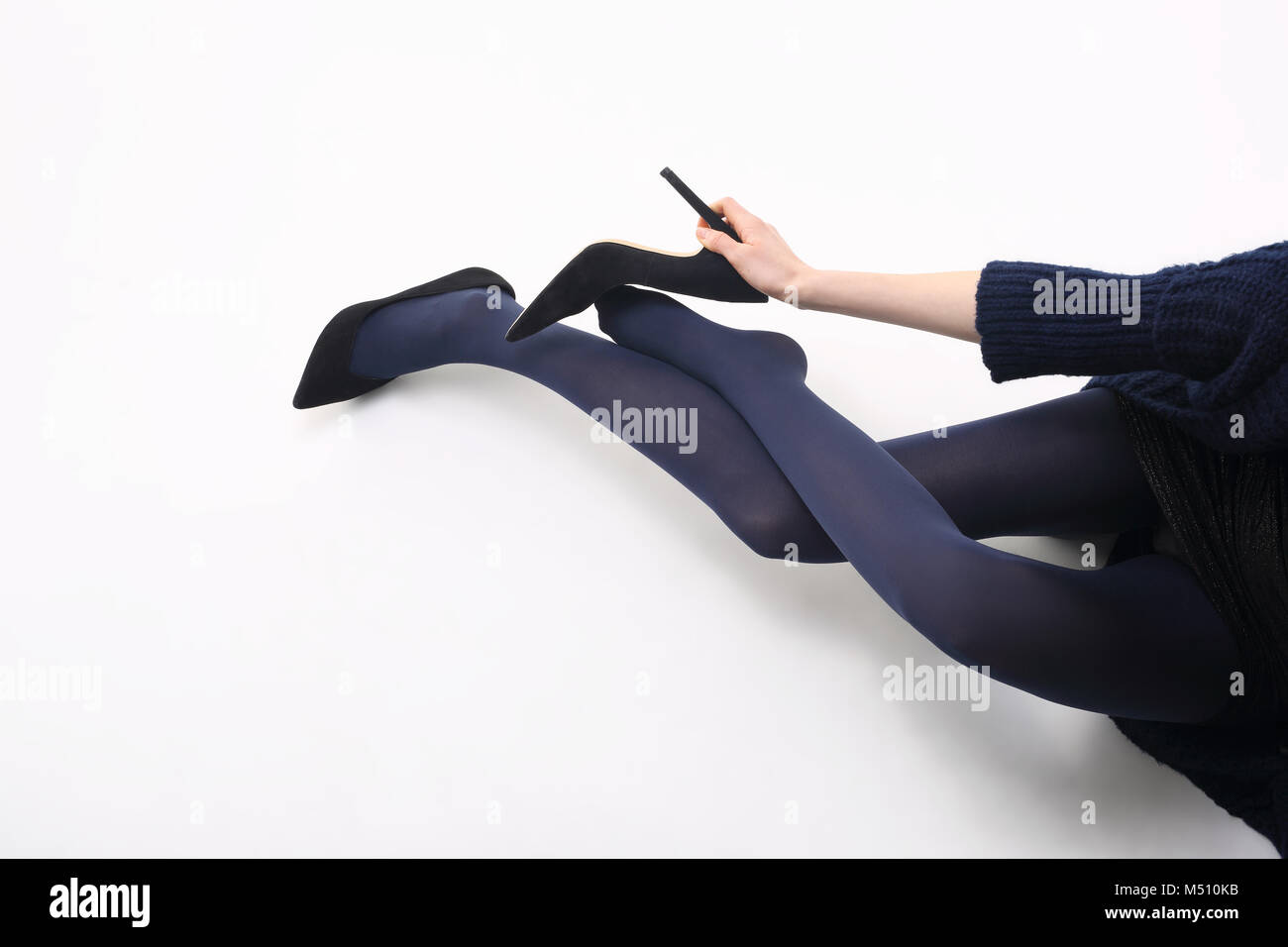 Tights.Woman's legs in  tights on a white background. Legs of a young woman in  tights. Female legs in  tights on a white background. Stock Photo