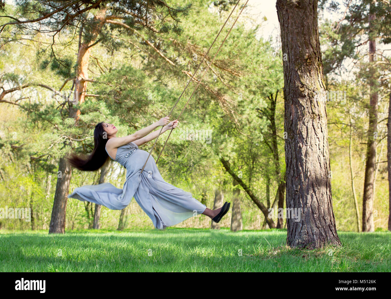 pregnant woman swinging on a swing Stock Photo Alamy