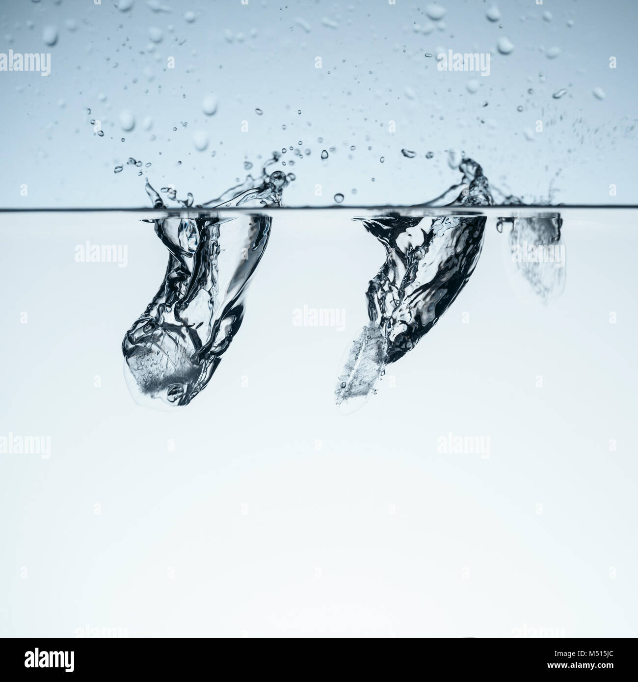 ice cubes in water with splashes, isolated on white Stock Photo - Alamy