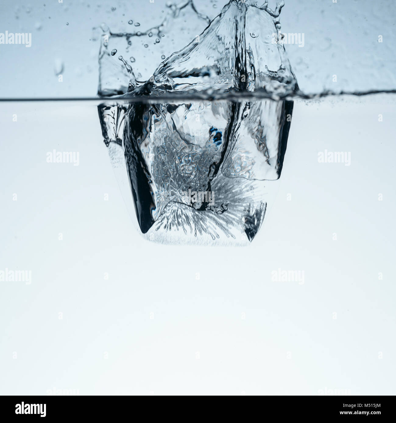 ice cube in water with splash, isolated on white Stock Photo - Alamy