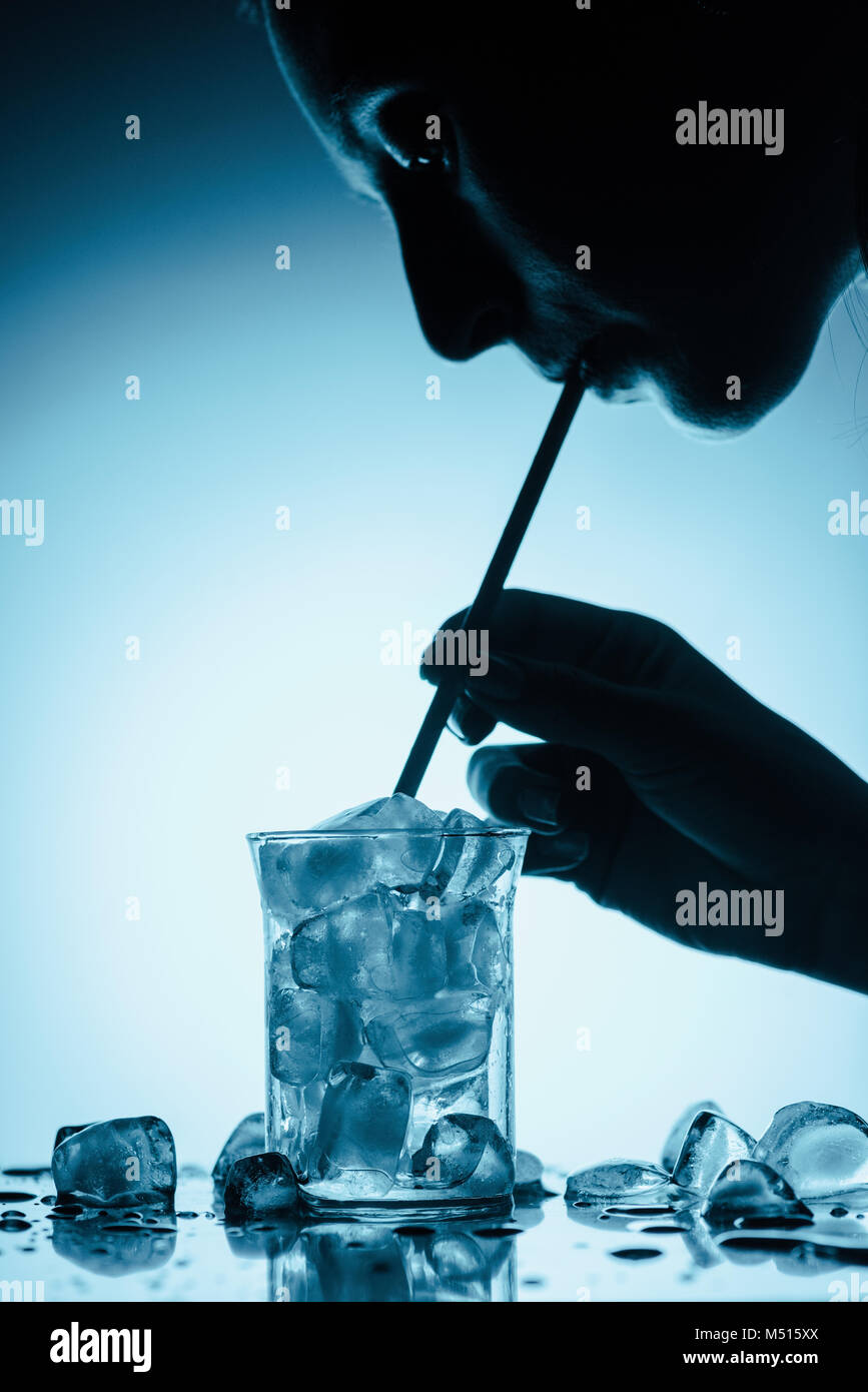 profile silhouette of woman drinking cold water with ice cubes with ...