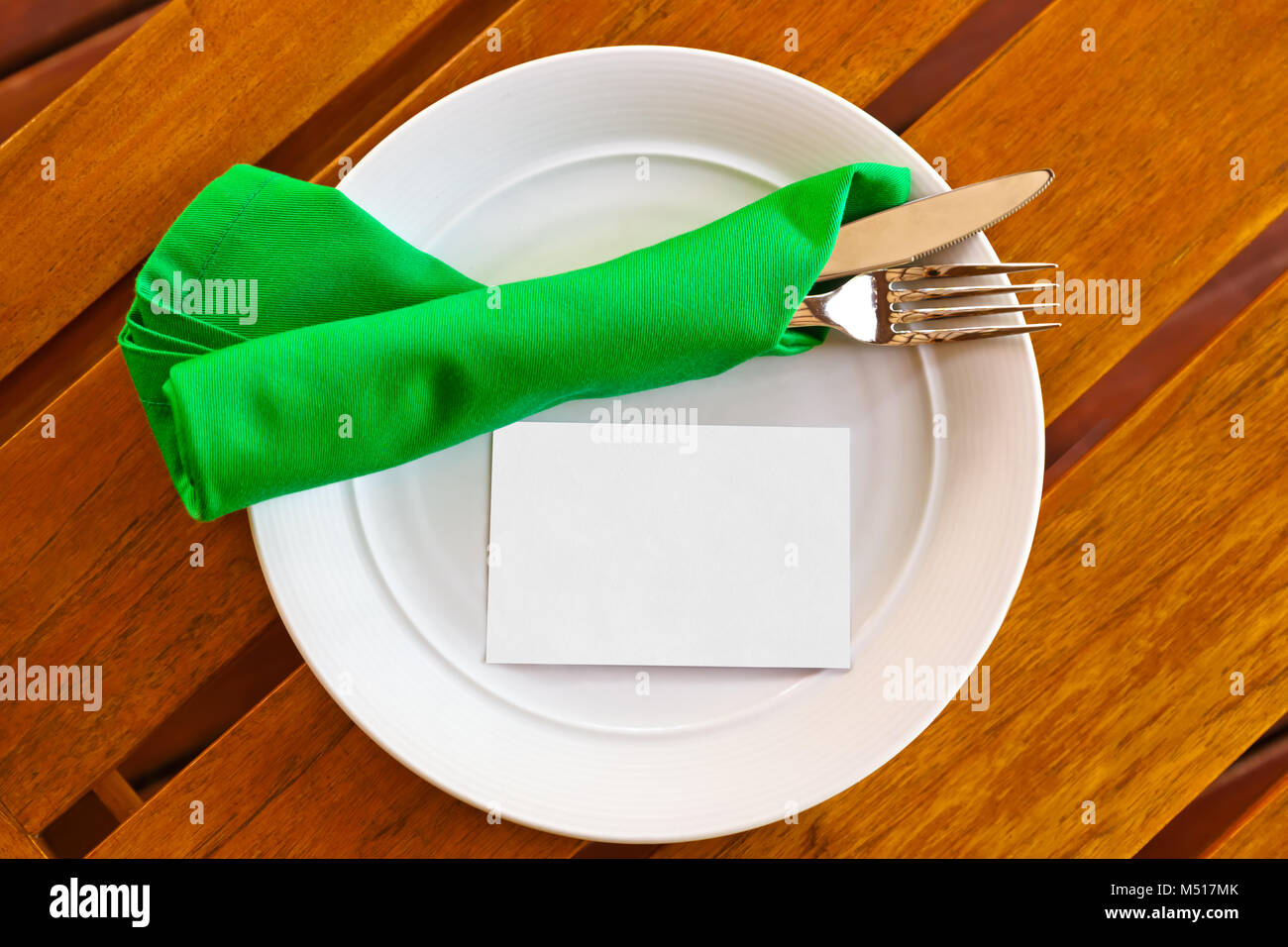 Dishware and blank paper card on table in restaurant Stock Photo