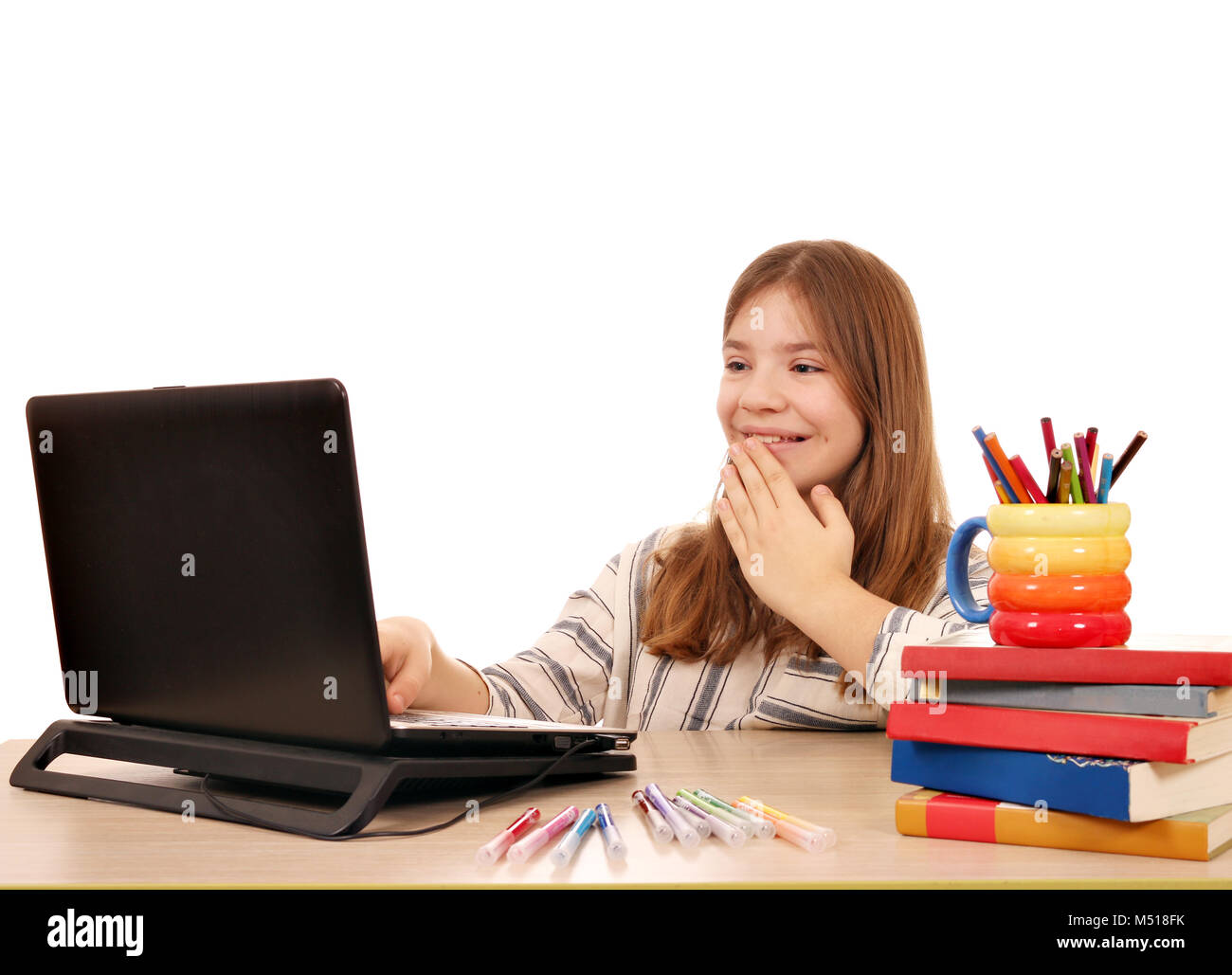 little girl looks at something fun on the laptop Stock Photo