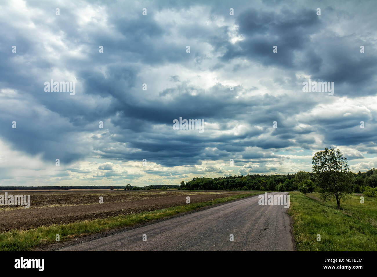 Mysterious clouds in the sky over an country road Stock Photo