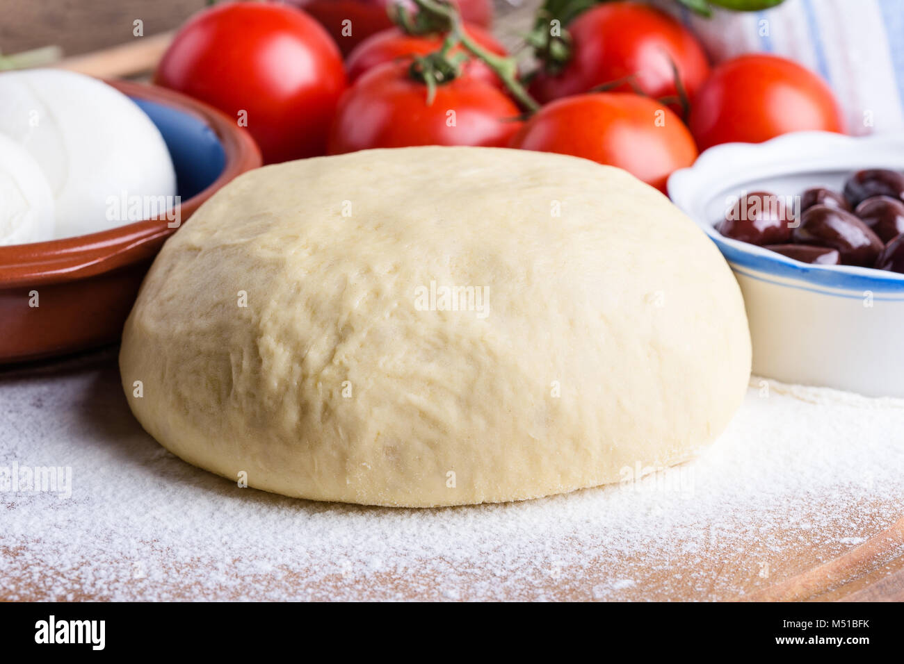 Making gourmet pizza with sprouts topping. Raw pizza dough with ingredients, close-up Stock Photo