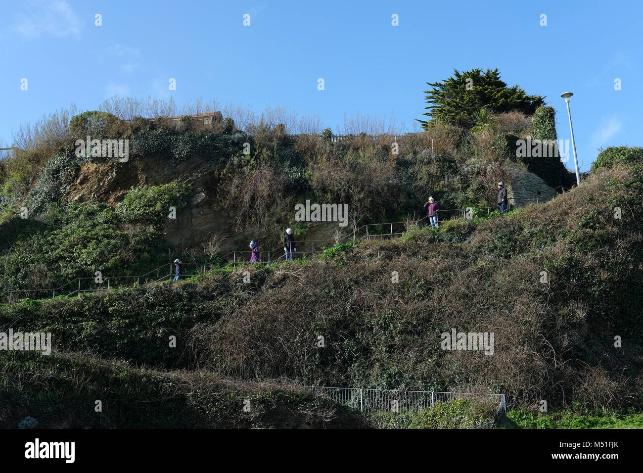 A family walking down a path in Cornwall. Stock Photo