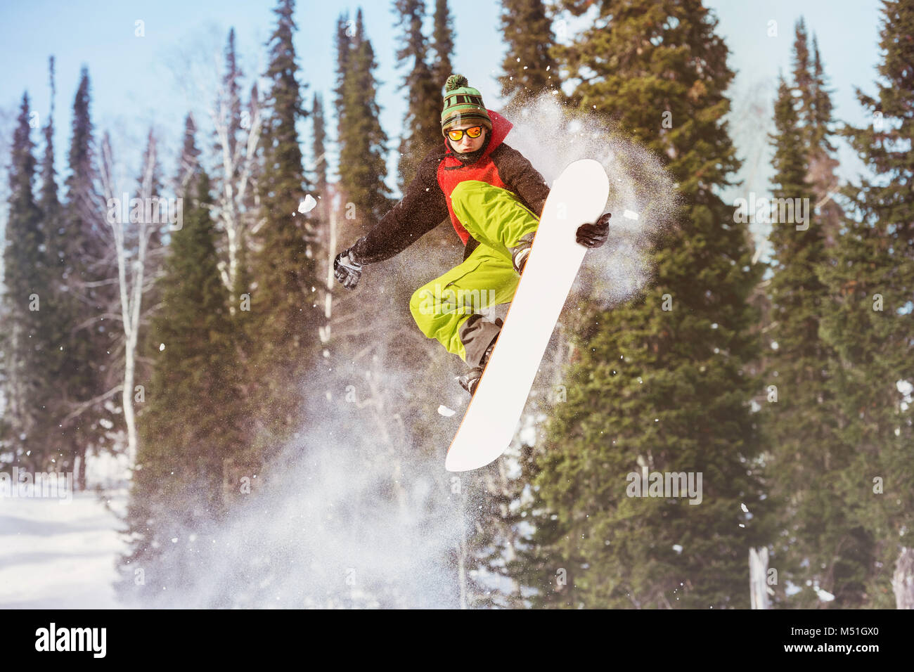 Snowboarder jumps at offpiste slope Stock Photo