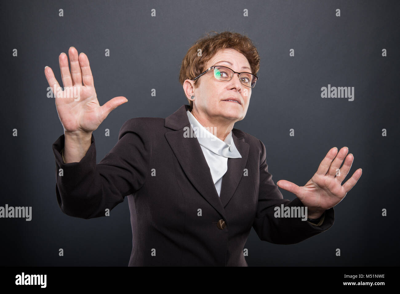 Lady Explaining Something Business senior lady holding hands like explaining something on black ...