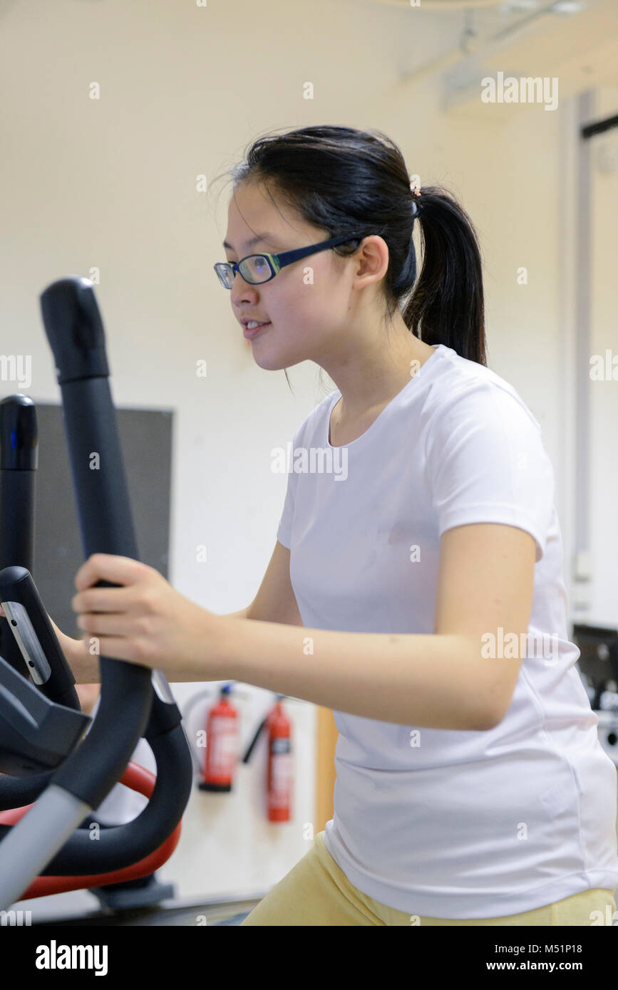 school students using the indoor gym equipment in a PE lesson Stock