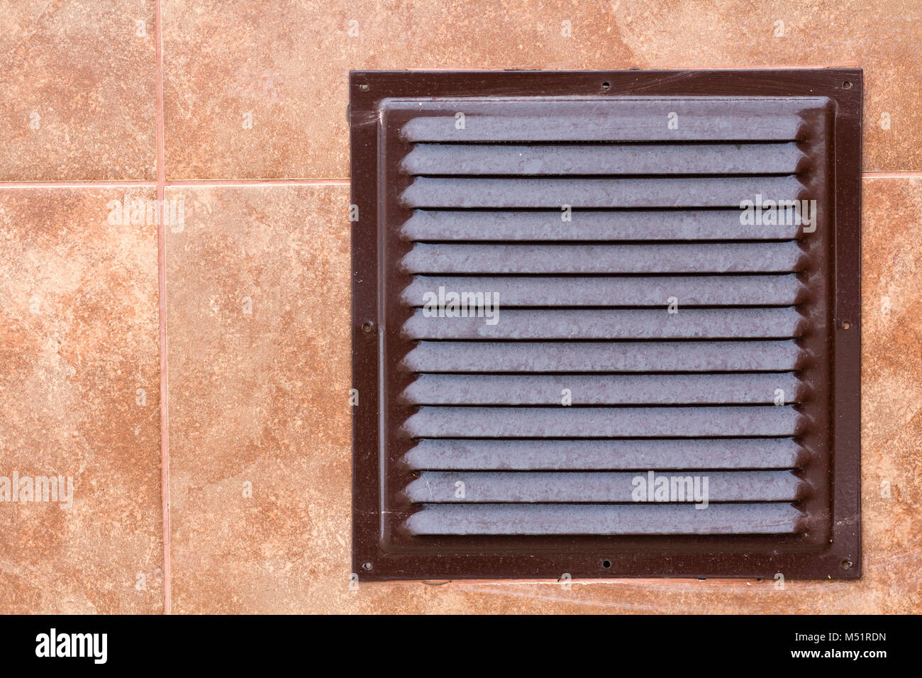 Brown metal industrial panel with ventilation grilles, closeup photo, front view. Detail of