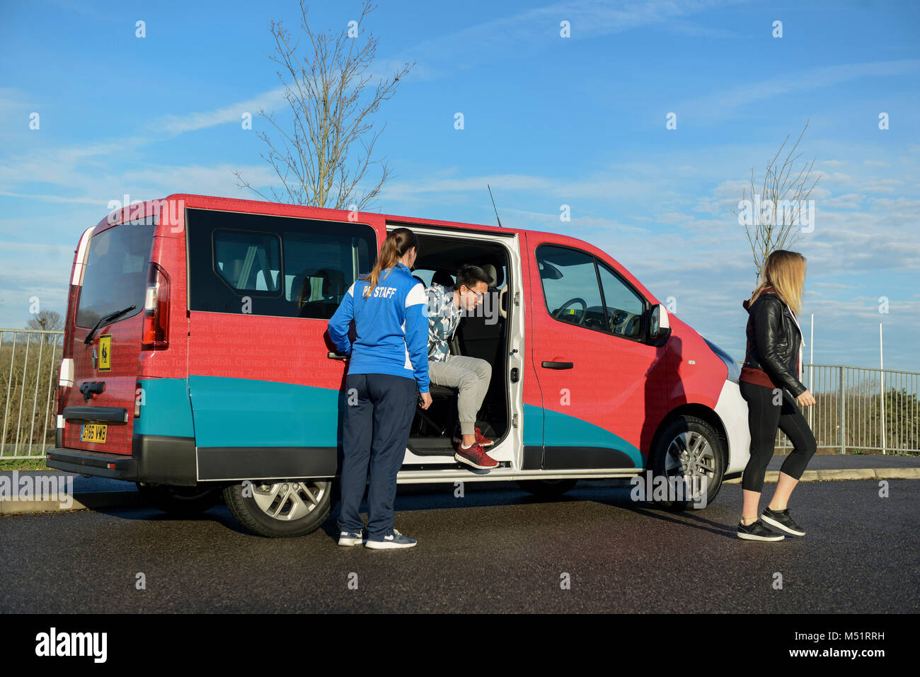 school college kids taking physical education / p.e. sports equipment out of the school van / mini bus before having a games / fitness lesson Stock Photo