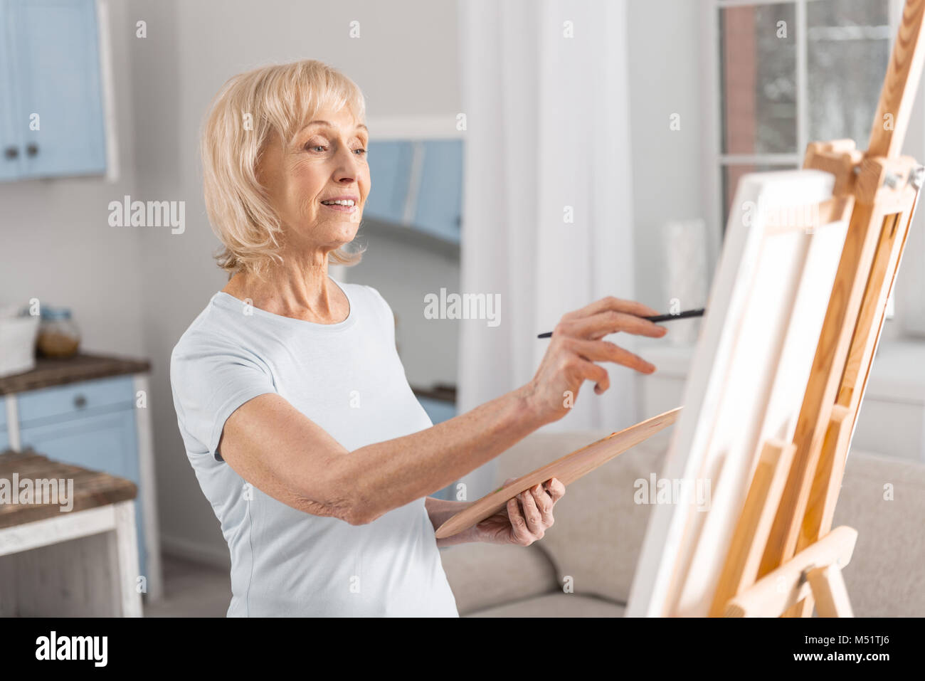 Inspired mature woman creating masterpiece Stock Photo