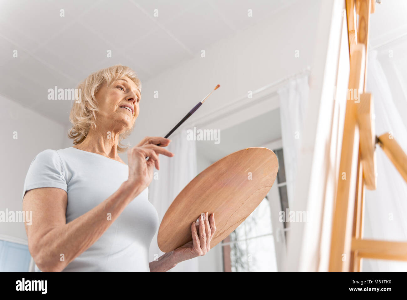 Dreamful mature woman coming up with idea Stock Photo