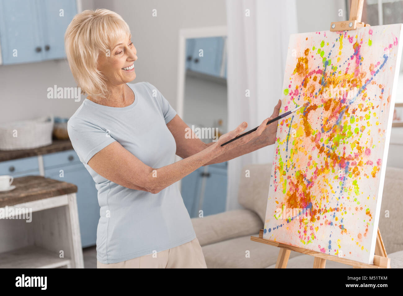 Joyful mature woman showing masterpiece Stock Photo