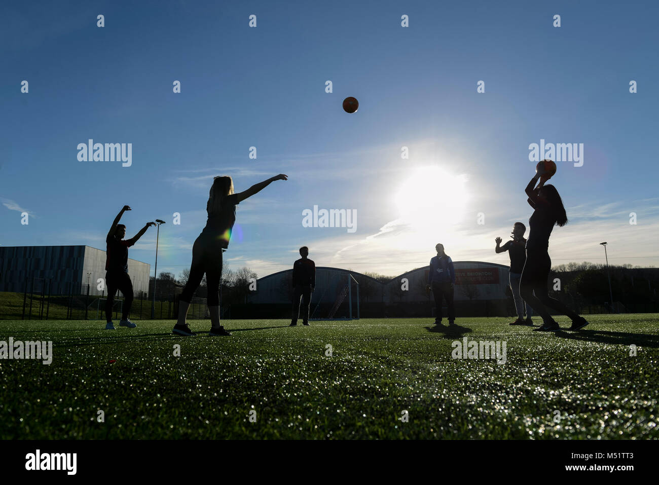 school students having a football lesson to improve their skills at playing sports on the football picth Stock Photo