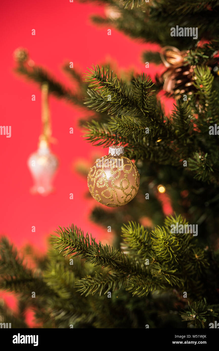 Christmas Tree on red background decorated with golden balls toys and ...