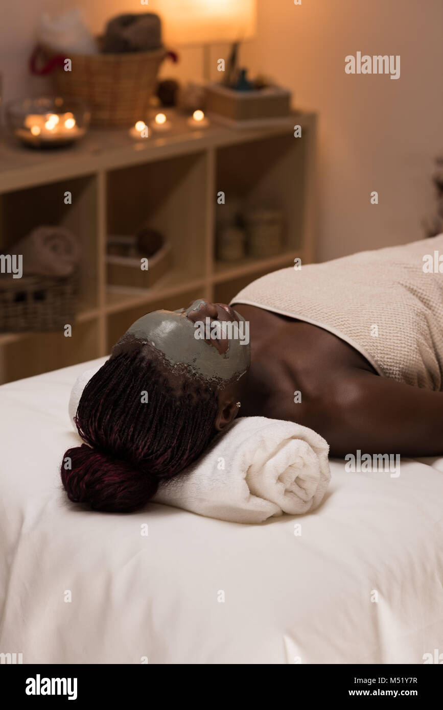 African beauty woman getting mud mask at spa Stock Photo