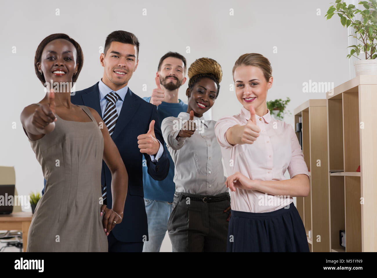 Business team celebrating a triumph with thumbs up Stock Photo - Alamy