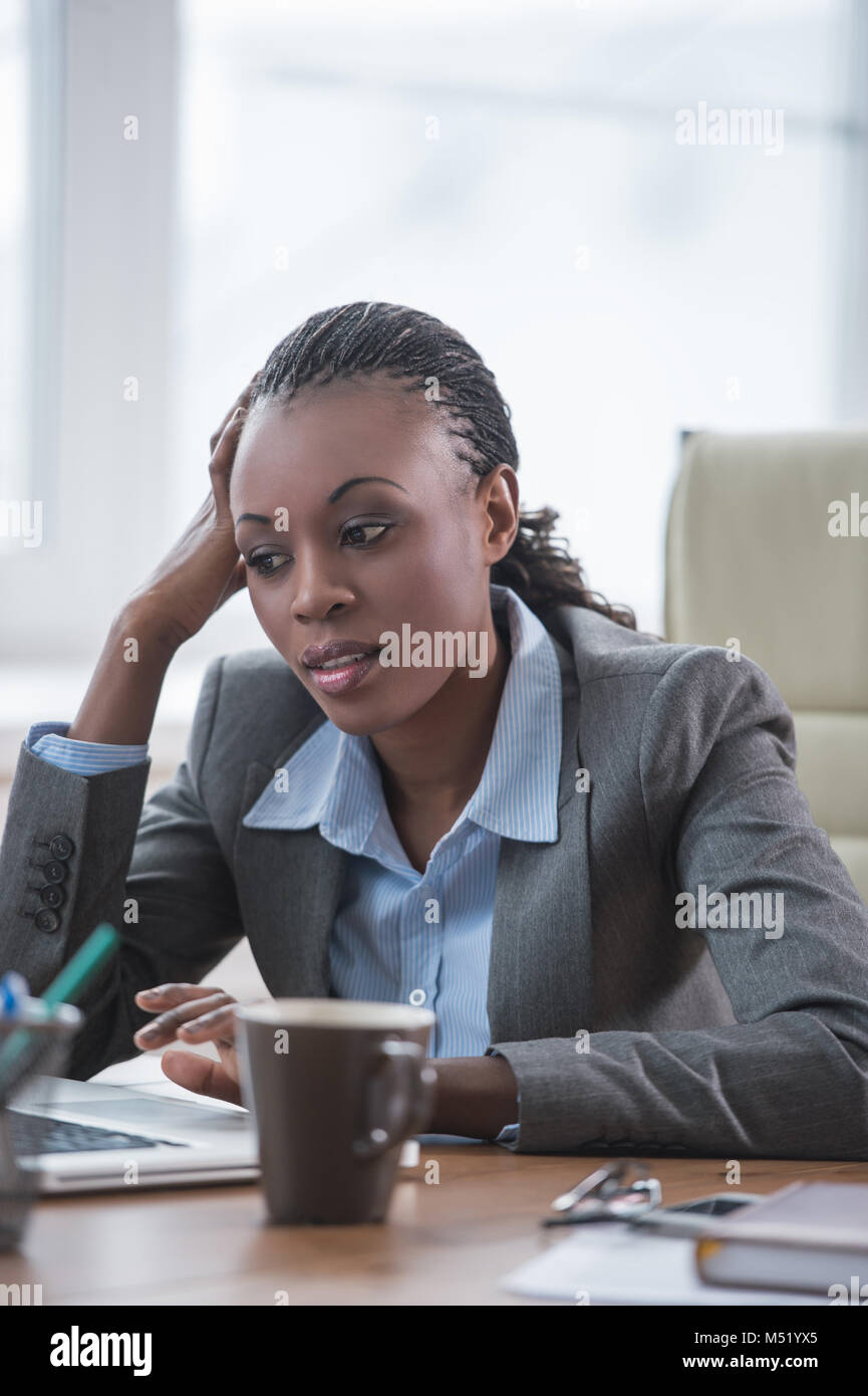 Pretty african business woman working on laptop in office Stock Photo ...