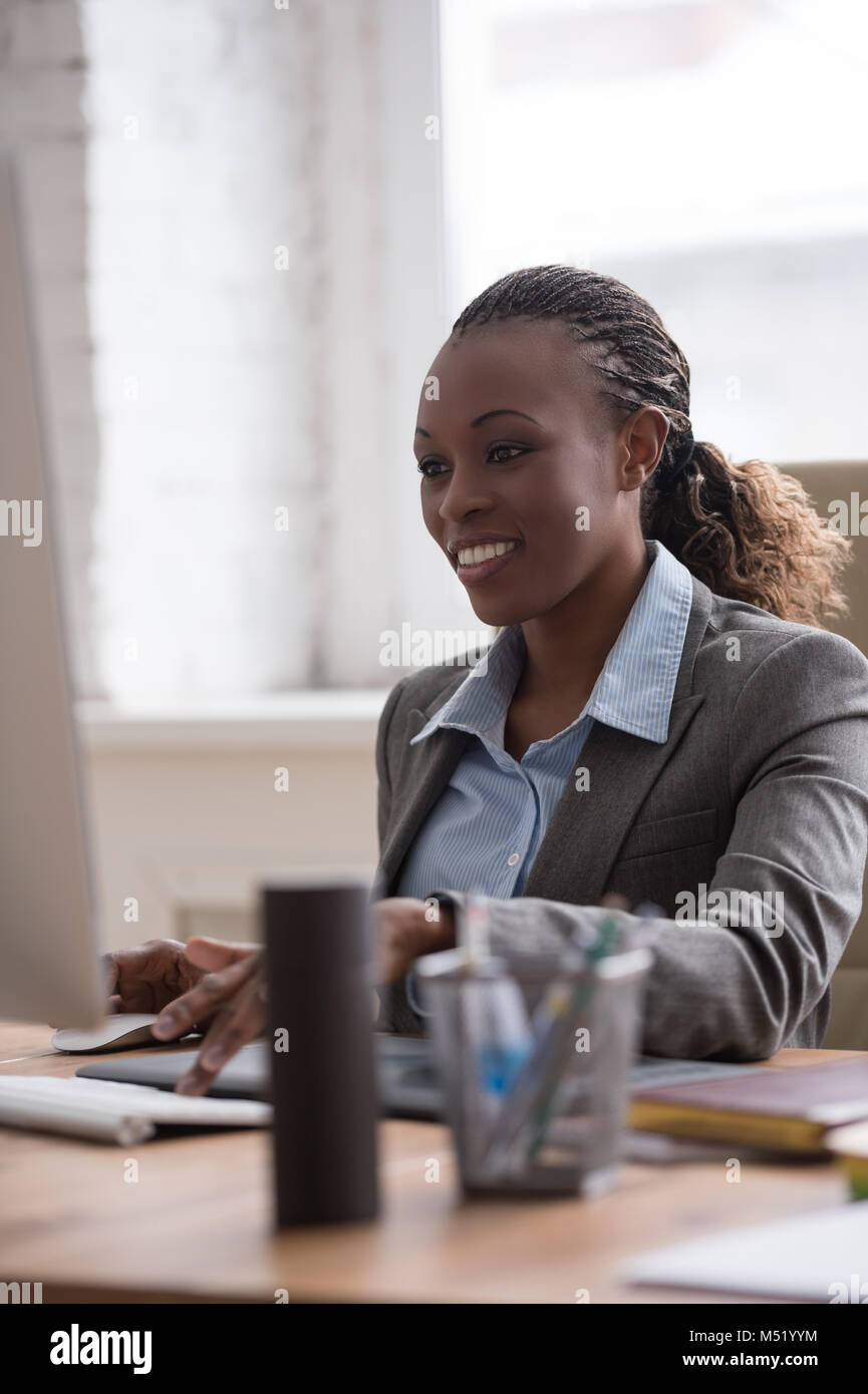 African pretty business woman working at pc in office Stock Photo - Alamy