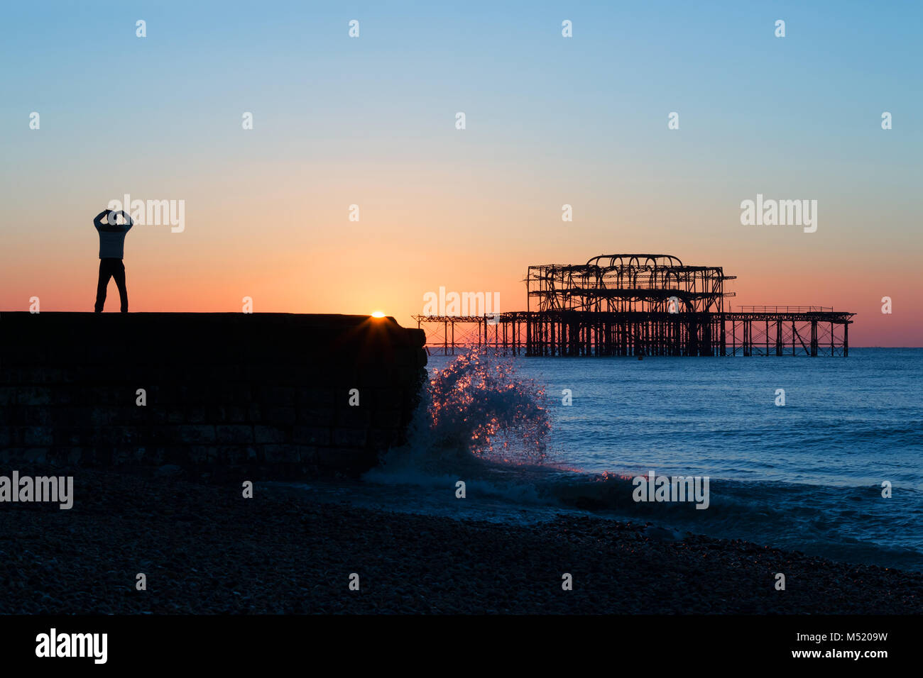 Person Doing Tai Chi By Brighton's West Pier at Dawn Stock Photo