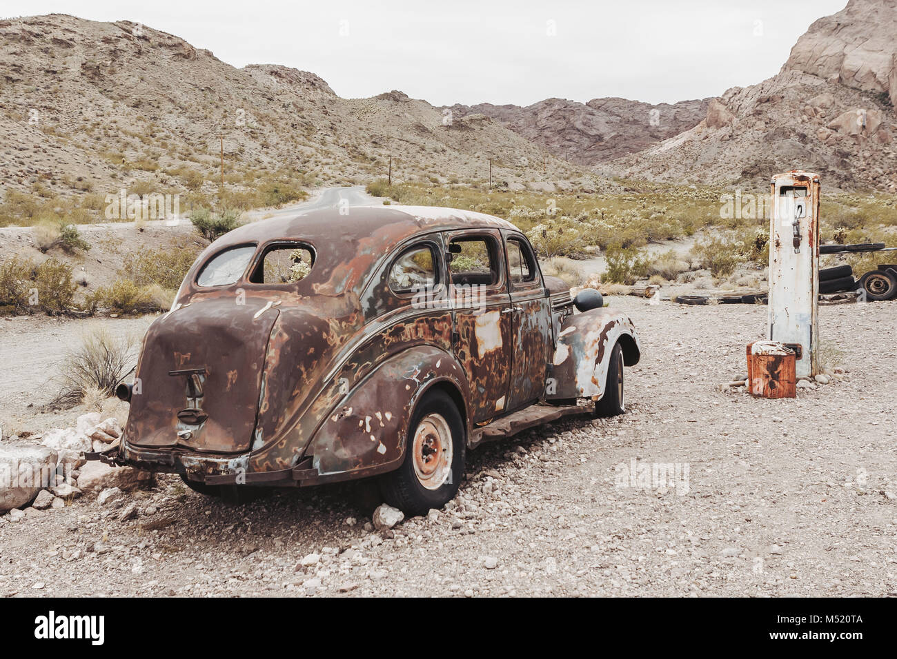 Old vintage rusty car truck abandoned near old fuel pump in the desert ...