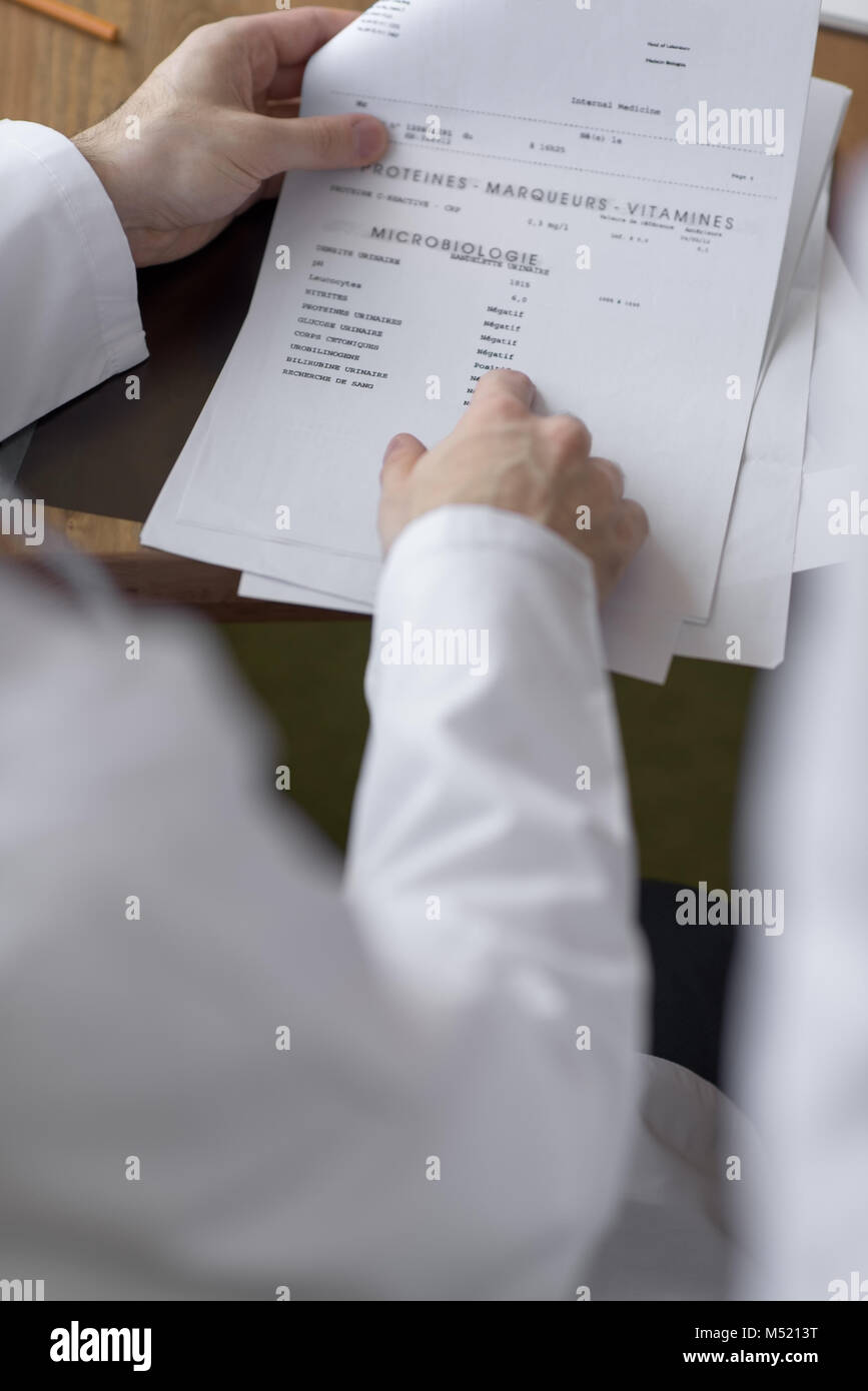Doctor working with test results of his patient at office Stock Photo