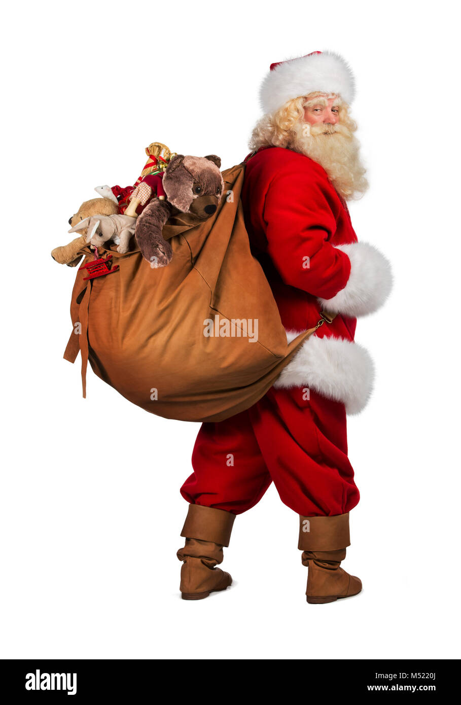 Full length portrait of Real Santa Claus carrying big bag full of gifts