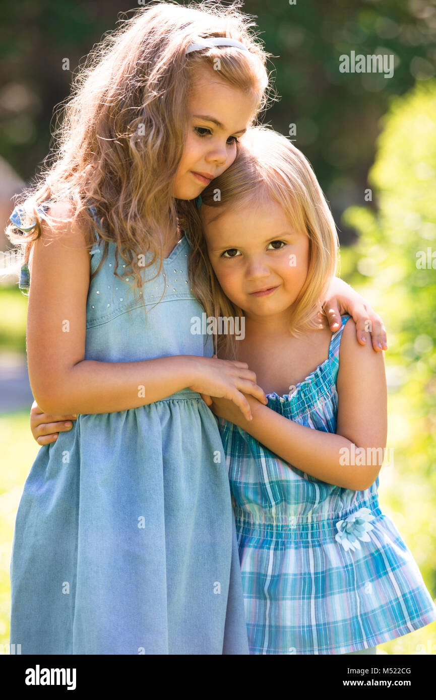 Outdoor portrait of two embracing cute little girls Stock Photo - Alamy