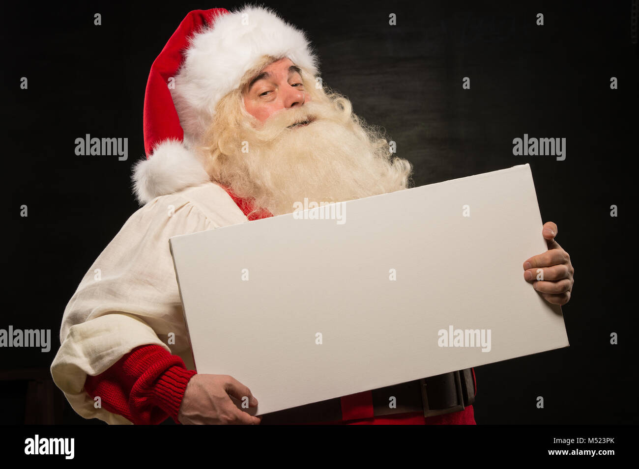 Santa Claus holding white blank sign with fun and smile standing ...