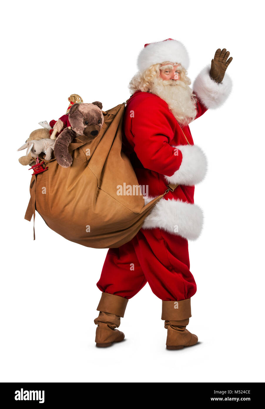Real Santa Claus carrying big bag full of gifts, isolated on white ...
