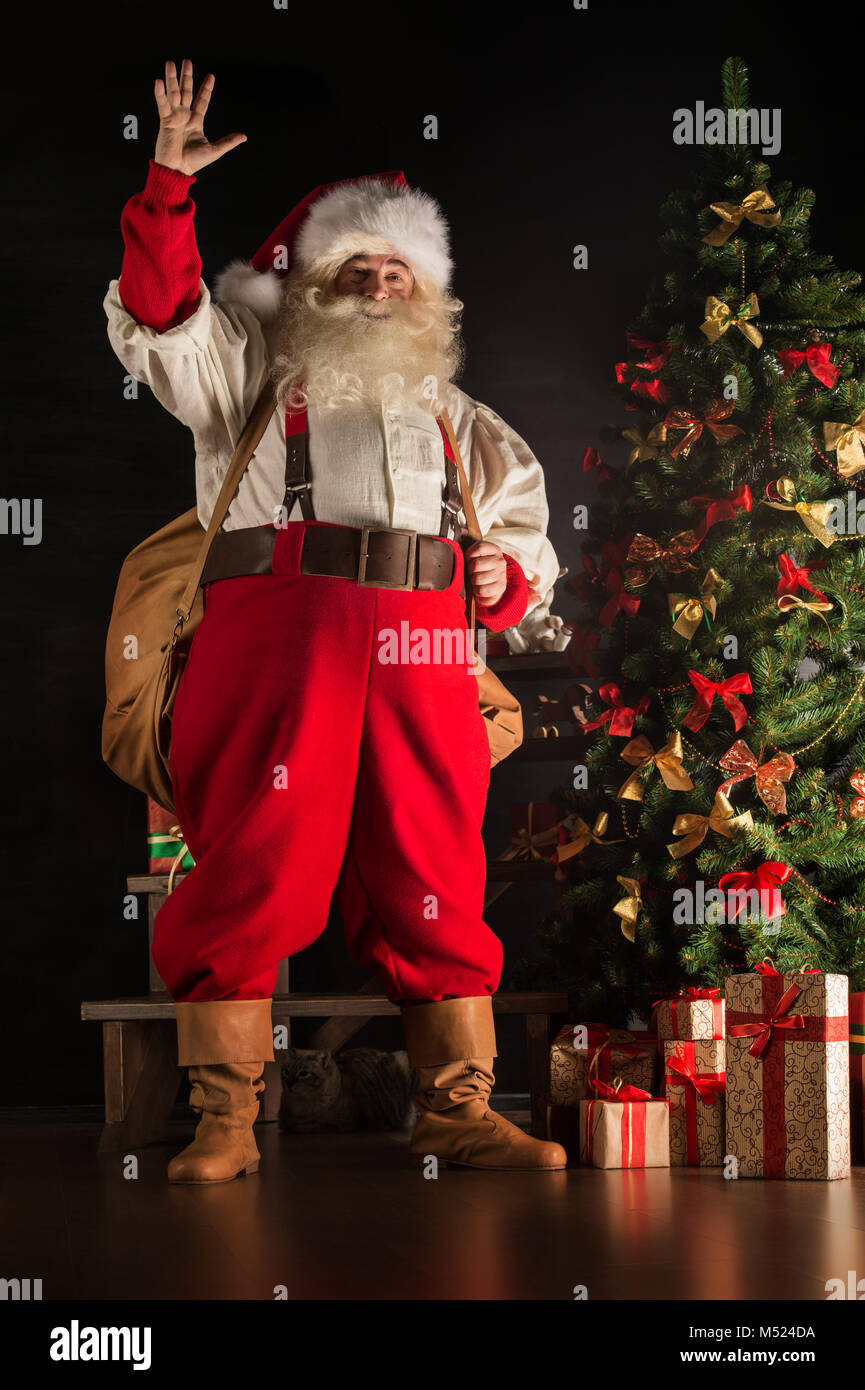 Full length portrait of Real Santa Claus carrying big bag full of gifts ...