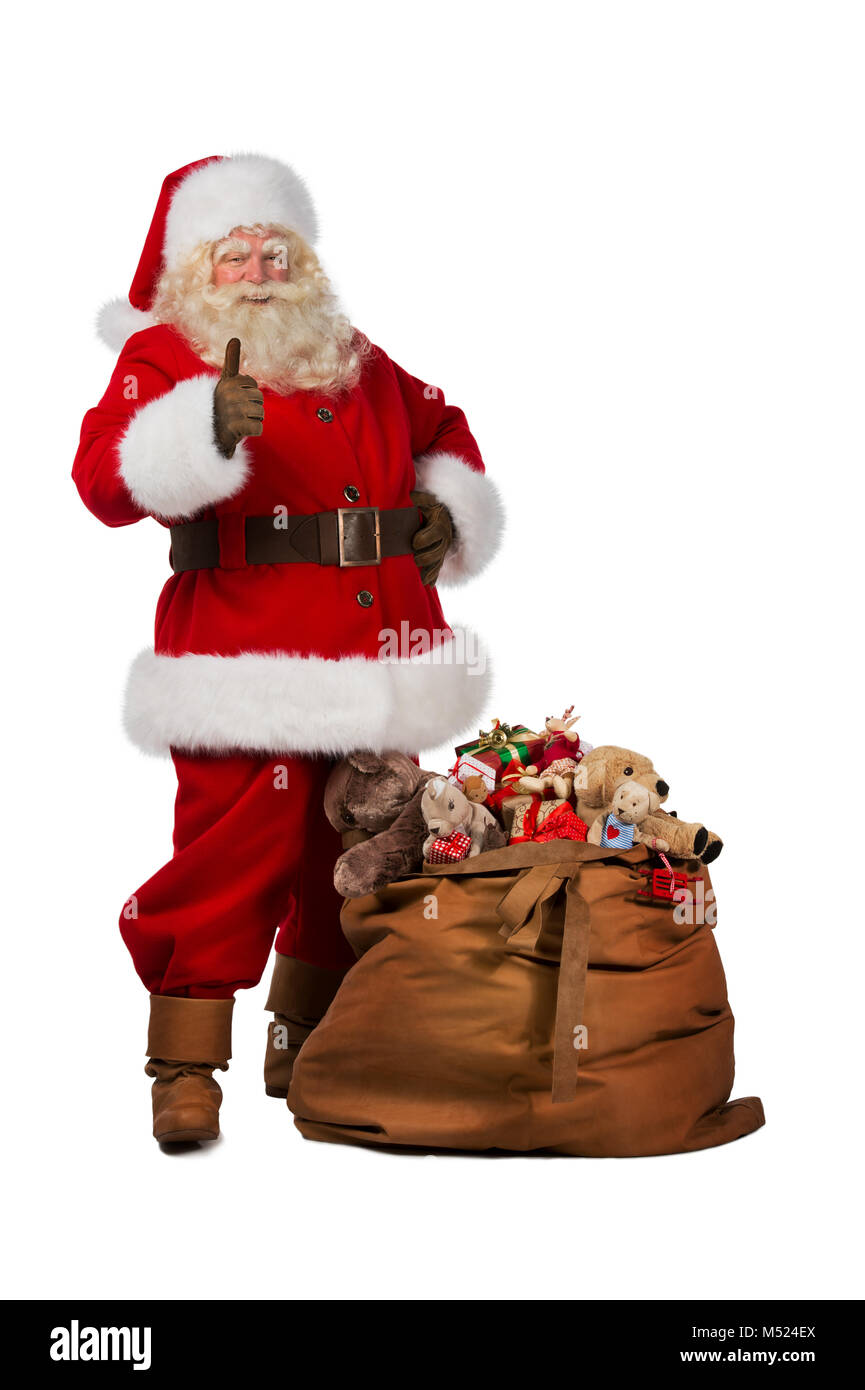 Full length portrait of a Santa Claus posing near a bag full of gifts ...