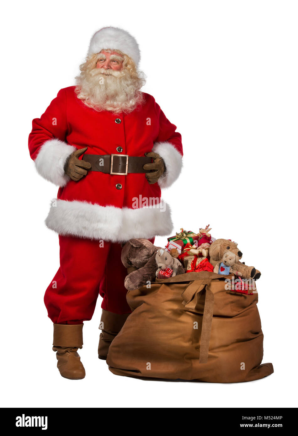 Full length portrait of a Santa Claus posing near a bag full of gifts ...