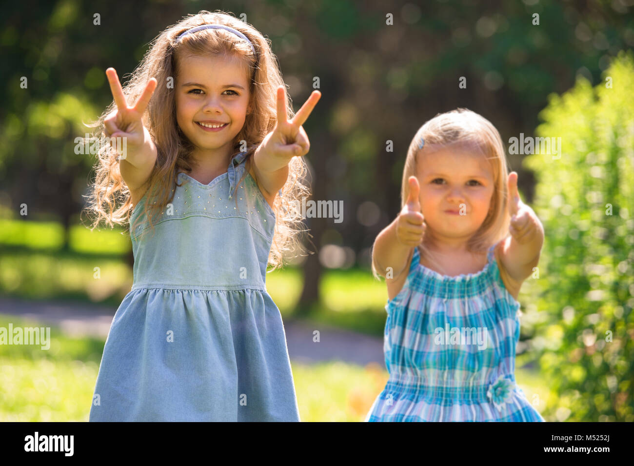 Happy childhood: Little girls having fun together outdoors in park ...