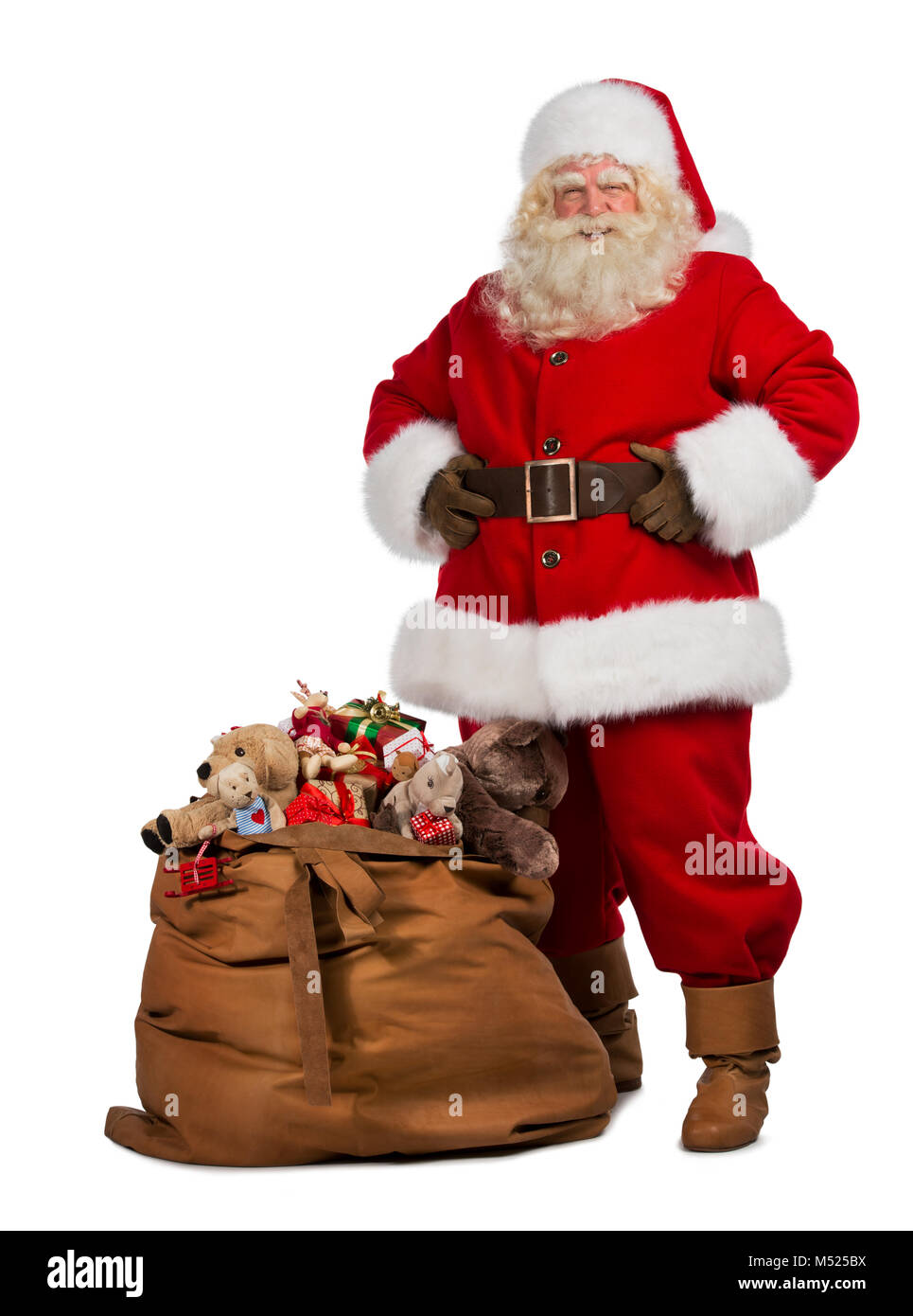 Full length portrait of a Santa Claus posing near a bag full of gifts ...
