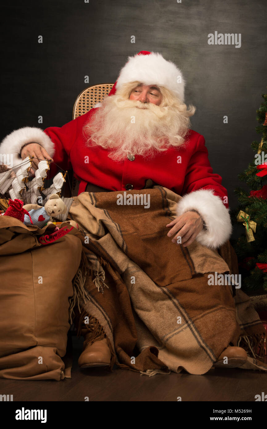 Santa Claus with a huge bag full of Christmas presents sitting in a ...