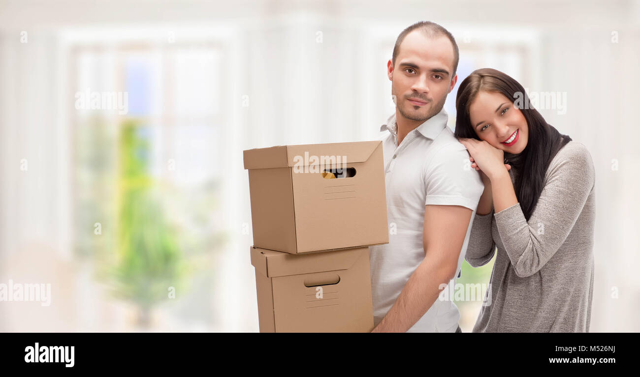 Young couple carrying cardboard boxes for their new home Stock Photo ...