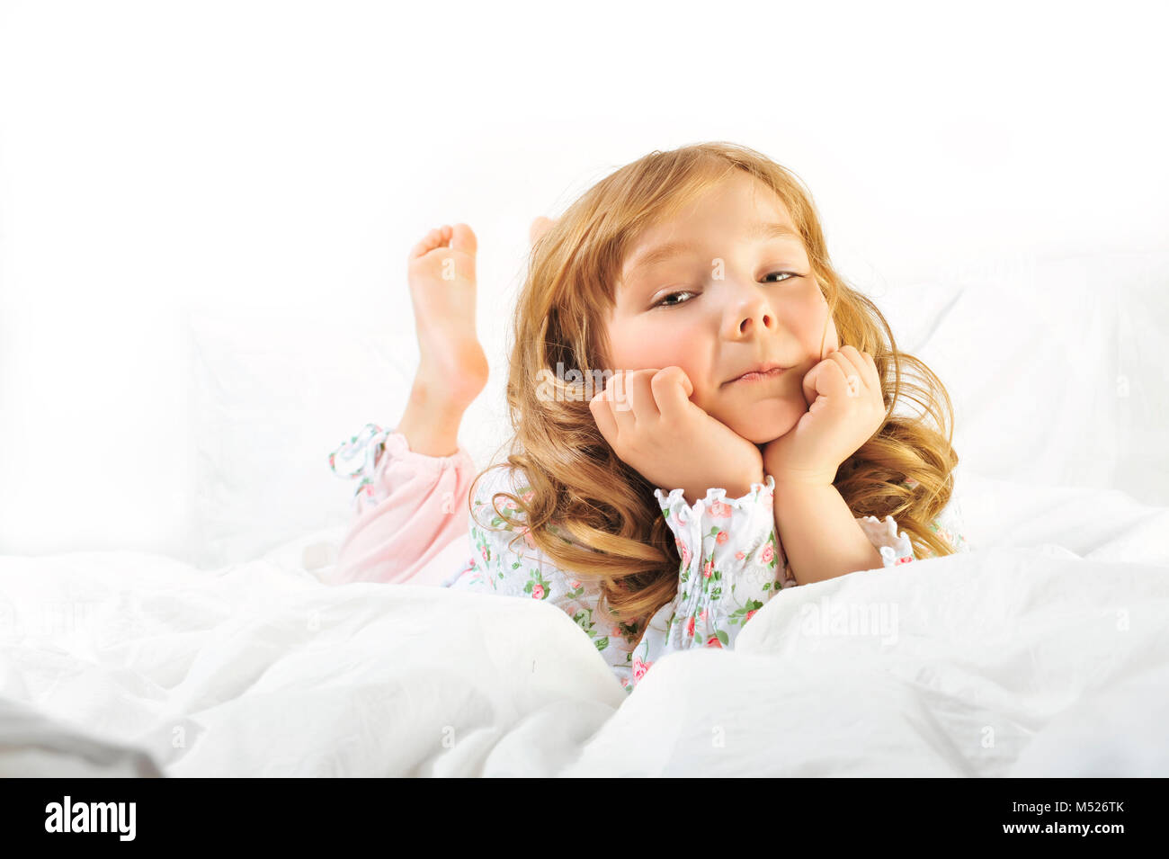 Cute little girl smiling on her with bed Stock Photo - Alamy