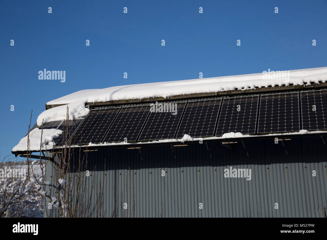 Solar Pv Panels On Side Of Barn In Snow Cotswolds Uk Stock